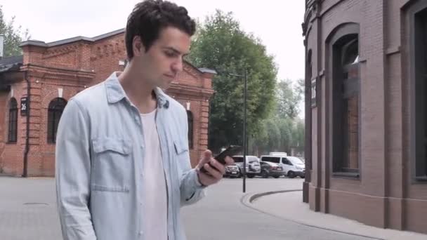 Walking Man upptagen med Smartphone på gatan — Stockvideo