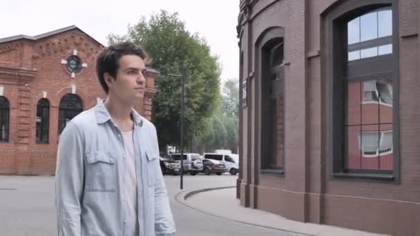 Молодой человек, гуляющий по улице — стоковое видео