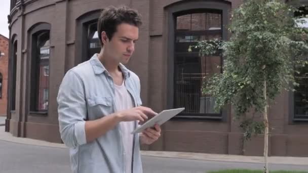 Alkalmi férfi séta, és használja a tablettát, Online böngészés közben — Stock videók