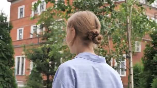 通りを歩いてカジュアルな女性の背面図 — ストック動画