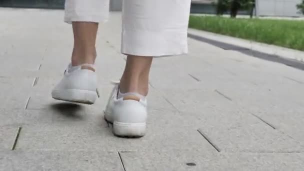 Κοντινό πλάνο του ΠΙΣΩ ΟΨΗ περπάτημα γυναικεία πόδια στον δρόμο — Αρχείο Βίντεο