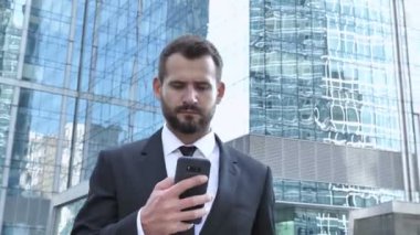 İşadamı Smartphone yürüyüş sırasında kullanarak