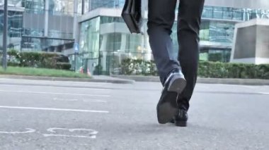 Arkadan görünüşü işadamı bacak yürüme ve el çantası