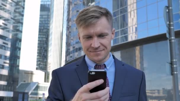 商人使用智能手机 站在办公室外 — 图库视频影像