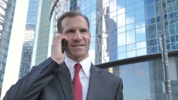 Ходячий Бизнесмен Средних Лет Разговаривает Телефону — стоковое видео