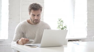 Dizüstü bilgisayarda adam tarafından banka kartı ile online ödeme