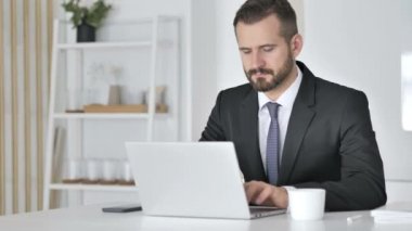 İşadamı ofiste dizüstü bilgisayarda çalışıyor.