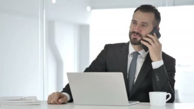 İş adamı telefonda konuşuyor.