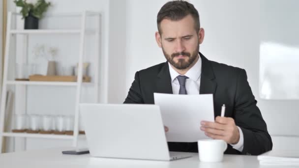 Empresario leyendo documentos en la oficina — Vídeo de stock