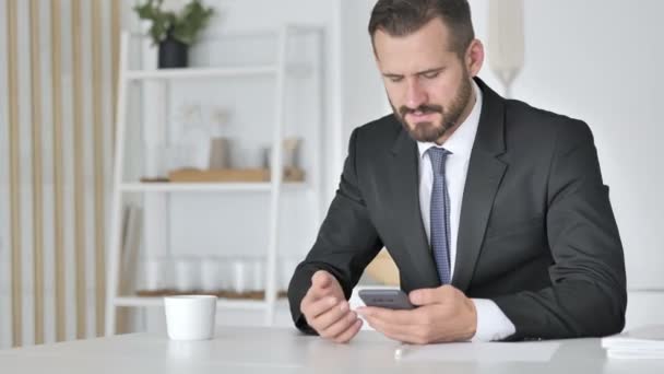 Man viert succes tijdens het gebruik van Smartphone — Stockvideo