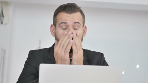 Empresario cansado frotando los ojos mientras trabaja en el ordenador portátil — Vídeos de Stock