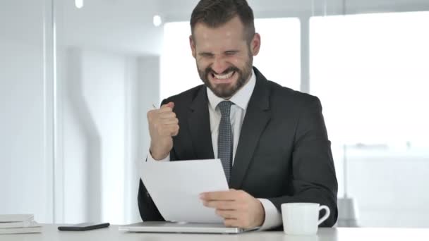 Empresario emocionado celebrando el éxito al leer documentos — Vídeo de stock