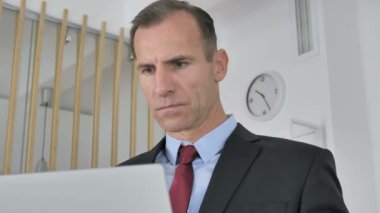 Dizüstü bilgisayar, hayretler içinde çalışma işadamı şok orta yaşlı