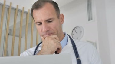 Dalgın doktor düşünme ve çalışma üstünde laptop