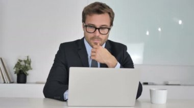 Düşünme ve dizüstü bilgisayarda çalışan iş adamı