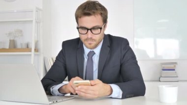 İş yerinde Smartphone kullanan İşadamı