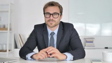 İş adamı ofisteki kameraya bakıyor