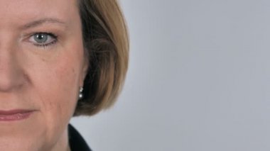 Yarım yüz ciddi yaşlı kadının kameraya, beyaz arka planı arıyorum