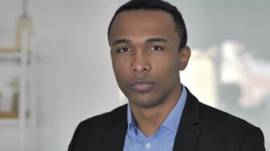 Başparmak aşağı kameraya bakarak rahat Afro-Amerikan işadamı tarafından