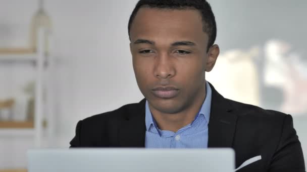 关闭疲惫的休闲非裔美国商人与颈部疼痛在工作 — 图库视频影像