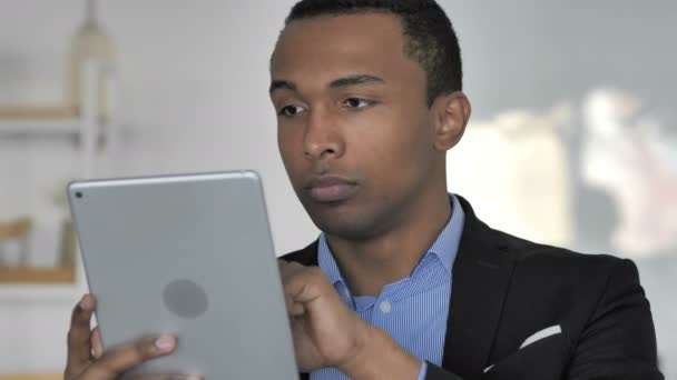 캐주얼 아프리카계 사업가 브라우징 인터넷 태블릿에 닫습니다 — 비디오
