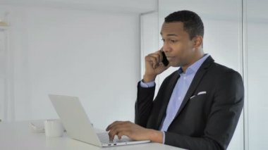 Telefon konuşma sırasında müşteri ile müzakere rahat Afro-Amerikan işadamı