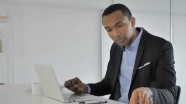 Casual Afro-Amerikan işadamı belgeleri ve Laptop üzerinde çalışma