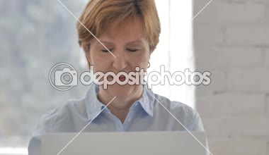 Yaşlı kadın iş yerinde kamera işaret