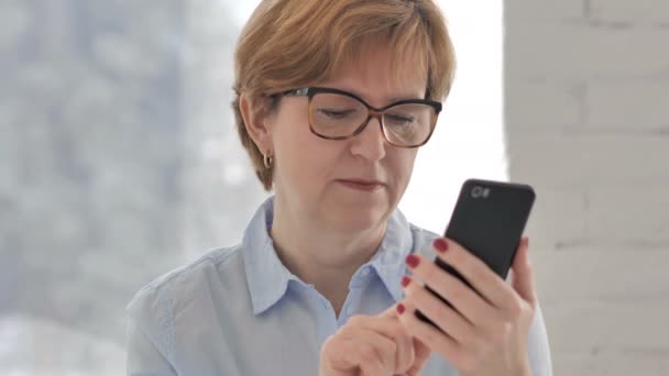 Alte Frau Steht Unter Schock Während Sie Ihr Smartphone Benutzt — Stockvideo