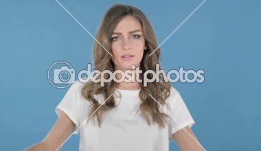 Genç kız üzerinde mavi arka plan el başparmak aşağı izole