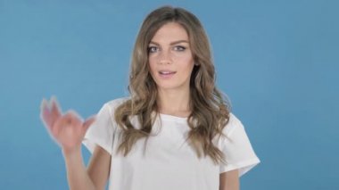 Genç kız üzerinde mavi arka plan izole Tamam işareti