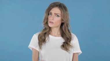 Genç kız üzerinde mavi arka plan izole öfkeyle mücadele