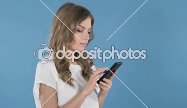 Genç kız heyecanlı başarı kullanarak Smartphone izole mavi arka plan üzerinde süre için