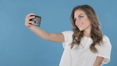 Selfie üzerinde mavi arka plan izole Smartphone ile alarak genç kız