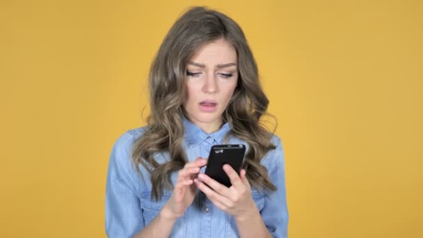 Jeune Fille Réagissant Perte Utilisant Smartphone Isolé Sur Fond Jaune — Video