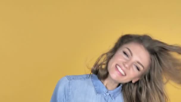 Szczęśliwa Młoda Dziewczyna Potrząsając Głową Białym Tle Nad Żółtym Tle — Wideo stockowe