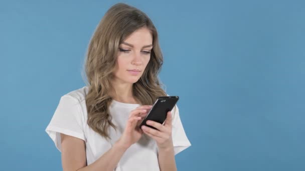 Aamzed Young Girl Excited While Using Smartphone Isolated Blue Background — Stock Video