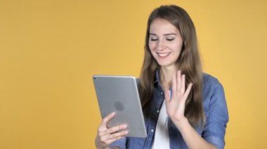 Sarı arka plan üzerinde izole Tablet ile güzel kadın tarafından görüntülü sohbet