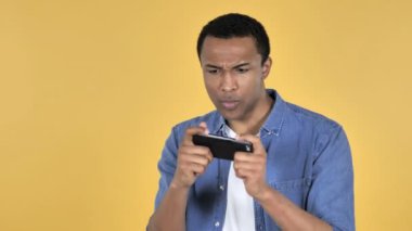 Afrika delikanlı üzerinde sarı arka plan izole Smartphone oyun oynamak