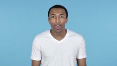 Mutlu hayran Afrika delikanlı hediye izole mavi arka plan üzerinde tarafından sürpriz