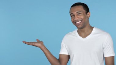 Afrika adam gösteren ürün yanında, mavi arka plan