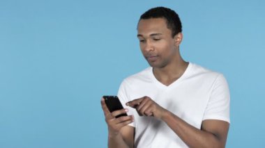 Afrika delikanlı Smartphone üzerinde mavi arka plan izole tarama