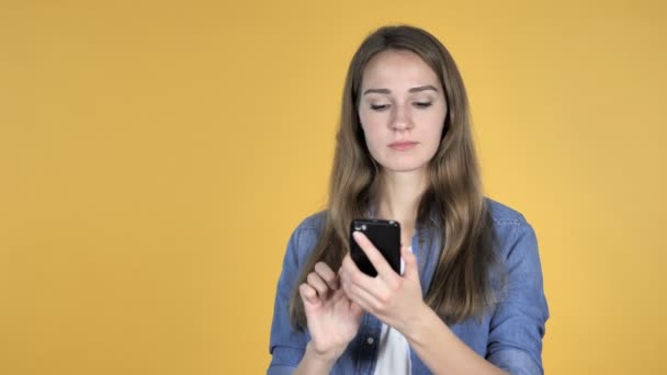 Jolie Femme Réagissant Perte Utilisant Smartphone Isolé Sur Fond Jaune — Video