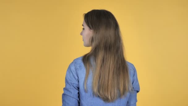黄色の背景に分離された周りに回すと 笑顔のきれいな女性 — ストック動画