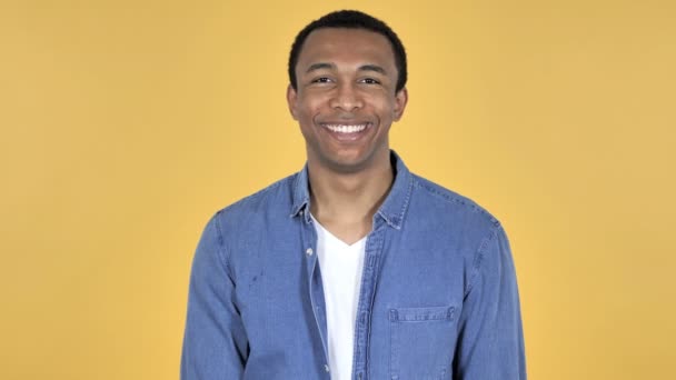 在黄色背景中孤立的微笑的非洲青年男子 — 图库视频影像
