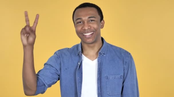 Знак Перемоги Молодого Африканця Ізольовано Жовтому Тлі — стокове відео