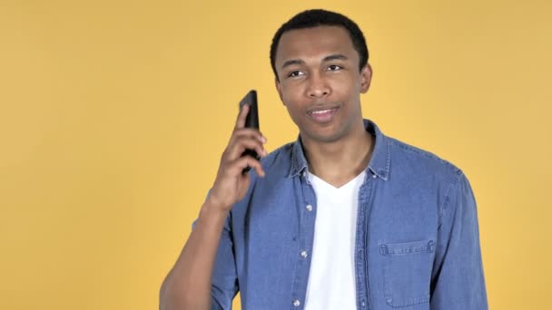 Jonge Afrikaanse Man Praten Smartphone Geïsoleerd Gele Achtergrond — Stockvideo