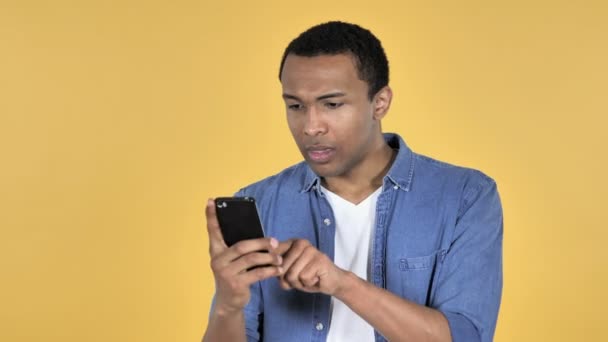 Homem Africano Jovem Choque Usar Smartphone Isolado Fundo Amarelo — Vídeo de Stock