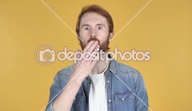 Kızıl saçlı adam sarı arka plan üzerinde izole tarafından uçan öpücük