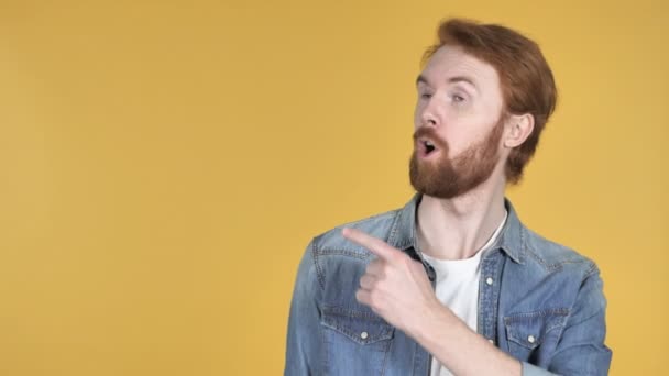 Homem Ruivo Apontando Com Dedo Lado Fundo Amarelo — Vídeo de Stock